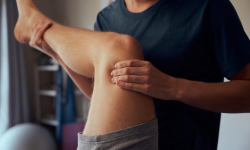 Doctor hands giving physiotherapy to patient knee